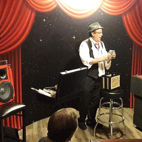 Eric Kurit performing comedy magic on stage at a Palm Beach event